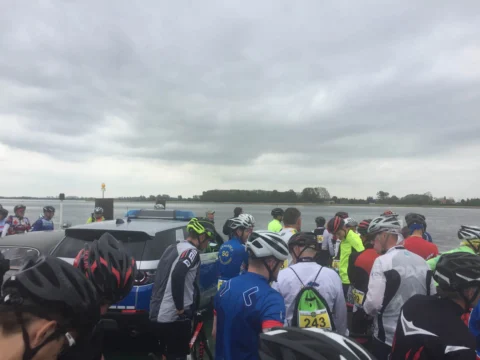 Dicht gedrängte Teilnehmende mit Helmen im Startbereich am Wasser