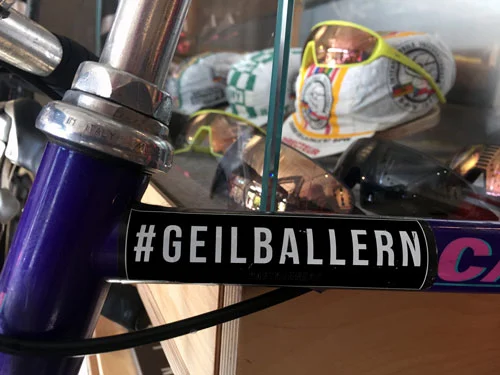 Nahaufnahme eines Fahrradlenkers mit dem Aufkleber „#GEILBALLERN“ auf dem Vorbau