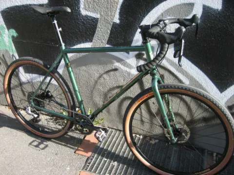 Das Kona Rove ST in Grün von der linken Seite an einer Graffitiwand