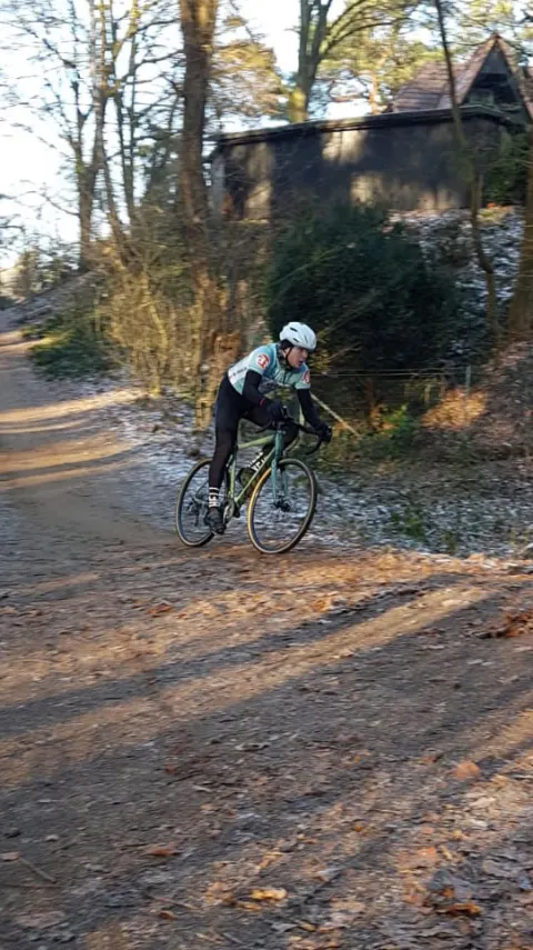 Ein Fahrer auf einem gefrorenen Feldweg zwischen Bäumen