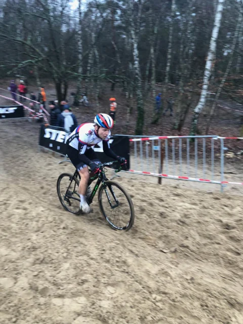 Ein Fahrer kurbelt durch tiefen Sand vor den Werbebanden