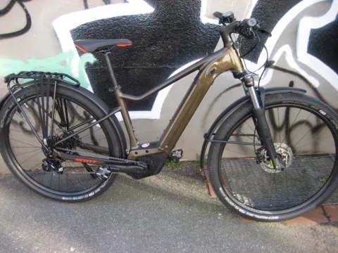 Das Scott Axis eRide 20 in Bronze von der linken Seite an einer Graffitiwand