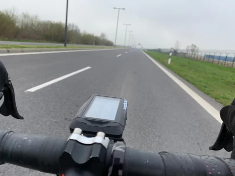 Blick über den Lenker auf eine leere Schnellstraße, auf dem Vorbau ein Radcomputer