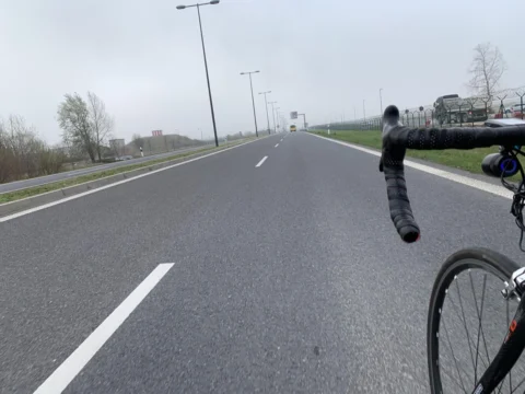 Blick über den Lenker auf eine leere, breite Straße im Dunst