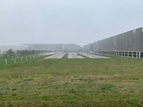Eine Wiese zwischen zwei leeren Fahrbahnen, dahinter das Parkhaus P7