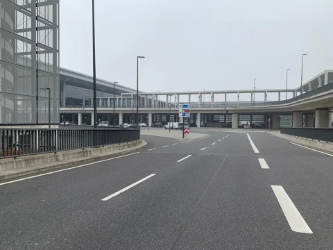 Eine leere Straße zwischen Terminal und Parkhaus, verbunden durch einen Übergang