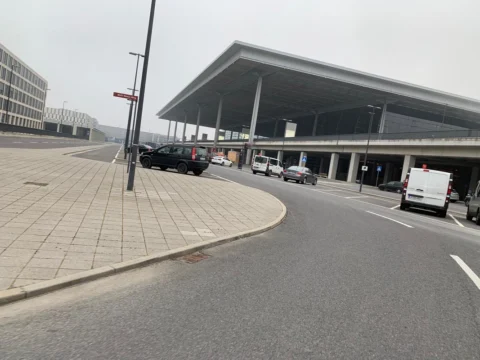 Die Vorfahrt am Terminal mit geparkten Autos unter dem weit auskragenden Dach