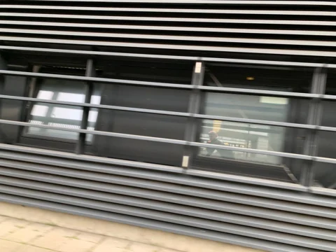 Nahaufnahme einer Lamellenfassade in der Vorbeifahrt, verwischt
