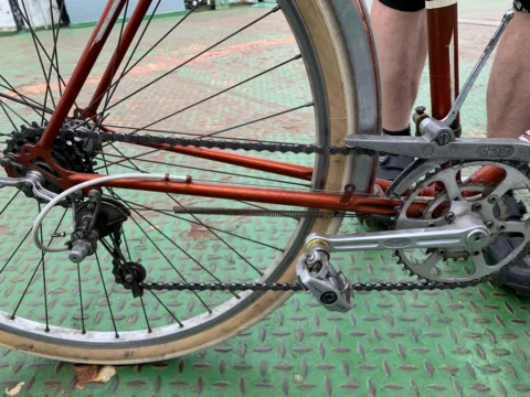 Detail eines alten roten Rennrads: Kettenblatt, Umwerfer und Pedale in Nahaufnahme