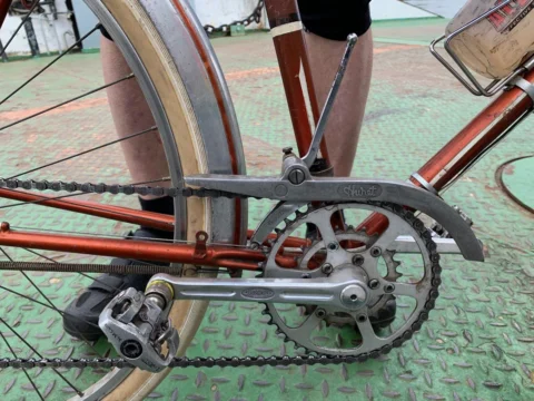 Detail eines alten Rennrads: Kurbel, Kettenschutz und Schuh auf dem Pedal