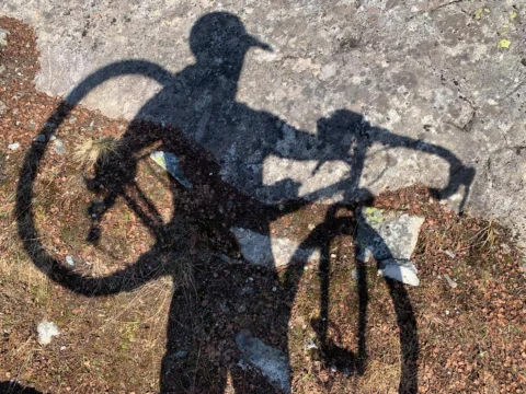 Der Schatten eines Radfahrers mit seinem Rad auf dem Fels