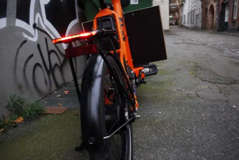 Das i:SY Cargo von hinten mit leuchtendem Rücklicht in einer Gasse