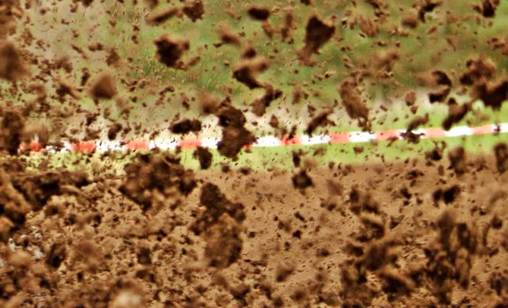 Aufgewühlter Matsch auf einer Cyclocross-Strecke, dahinter das Absperrband