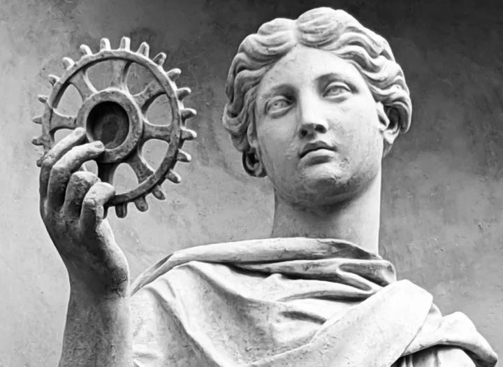 Statue einer Göttin im Park Sanssouci, in der erhobenen Hand ein Zahnrad