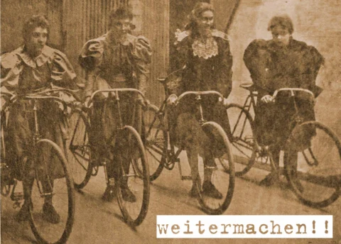 Historische Aufnahme in Sepia: vier Frauen in langen Kleidern mit ihren Fahrrädern, dazu der Schriftzug „weitermachen!!“