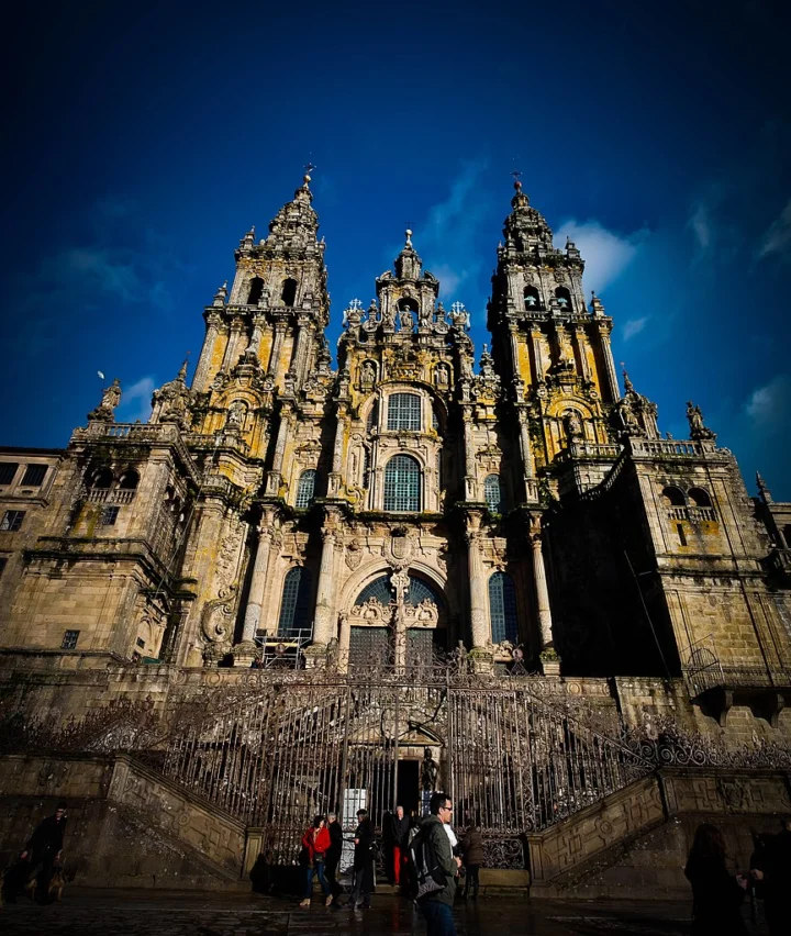 Die Kathedrale von Santiago de Compostela von unten gesehen, zwei Barocktürme vor tiefblauem Himmel