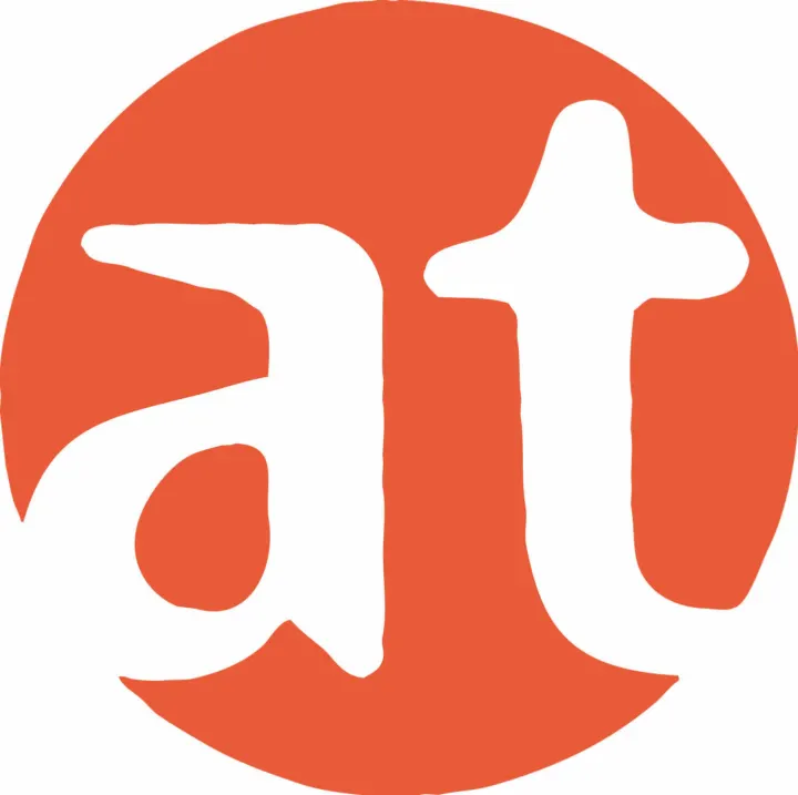 Das Logo von at Fahrräder: ein weißes „at“ in einem orangefarbenen Kreis