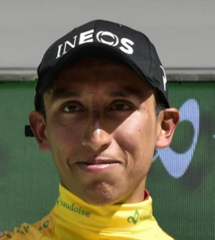 Egan Bernal im gelben Trikot und dunkler Kappe, Nahaufnahme auf dem Siegerpodest