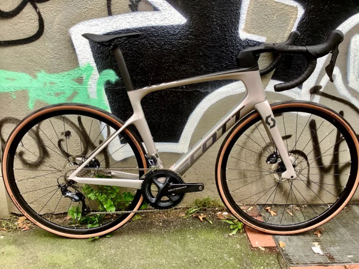 Das Scott Foil RC 30 in hellem Beige von der linken Seite an einer Graffitiwand