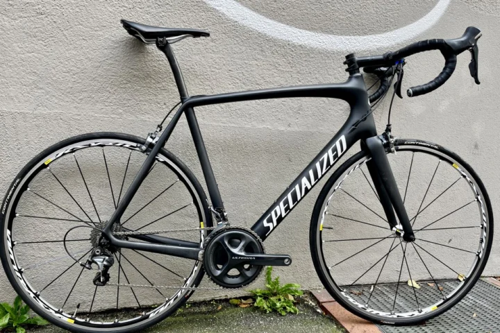 Ein schwarzes Specialized Tarmac von der linken Seite an einer Betonwand