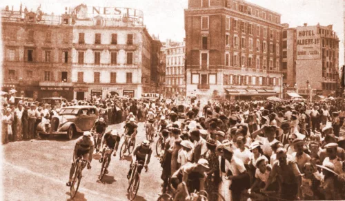 Das Peloton bei der Tour de France 1935 beim Start in Nizza Richtung Cannes bei at Fahrräder in Lübeck (Quelle: Tour de France 2024 - die Route von Florenz nach Nizza bei at Fahrräder in Lübeck (Foto: Anonym, Public domain, via Wikimedia Commons)