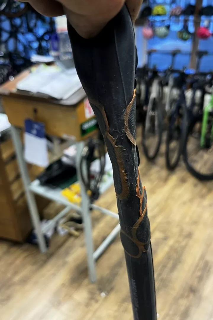 Ein Fahrradmantel mit mehreren aufgeklebten Flicken, von innen fotografiert