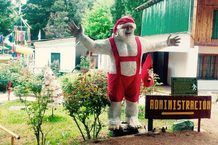 Eine überlebensgroße Weihnachtsmannfigur mit ausgebreiteten Armen vor einem Verwaltungsgebäude