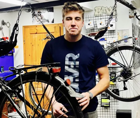 Daniel Nolte in der Werkstatt, vor ihm ein Fahrrad im Montageständer