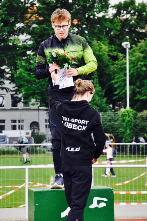 Friedrich Hegge gewinnt den Sieben-Türme-Triathlon 2024 in Lübeck! Davon berichtet stolz at Fahrräder, der Fahrradladen in deiner Stadt