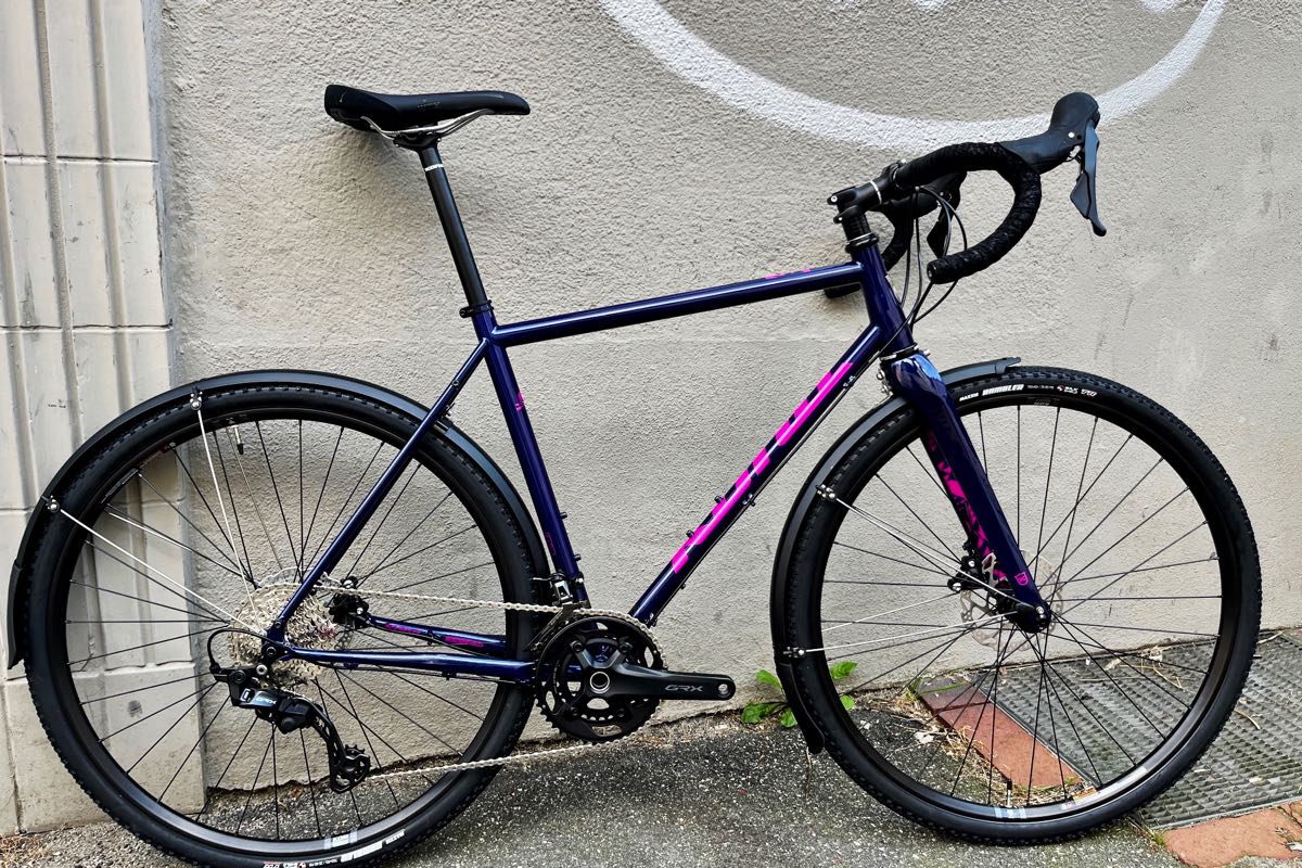 Gravel-Rad Gravel Gravel-Bike Kona Rove LTD 2025 mit Shimano GRX in Navy-Purple-Pink und Cromoly-Stahl-Rahmen plus Carbon-Gabel - bei at Fahrräder, deinem Fahrradladen in Lübeck mit Liebe zum Gravlen, zum Rennrad und zentraler Fahrradwerkstatt