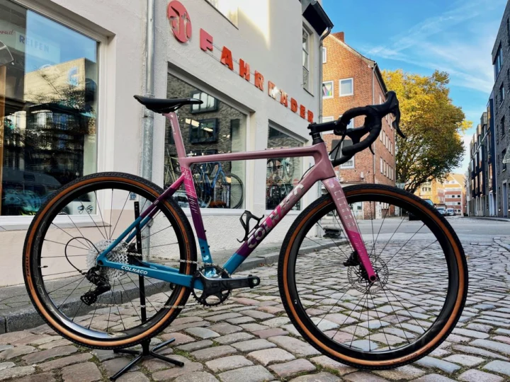 Das Colnago G3-X „Purple Rain“ von der anderen Seite, dahinter die Straße und der Laden