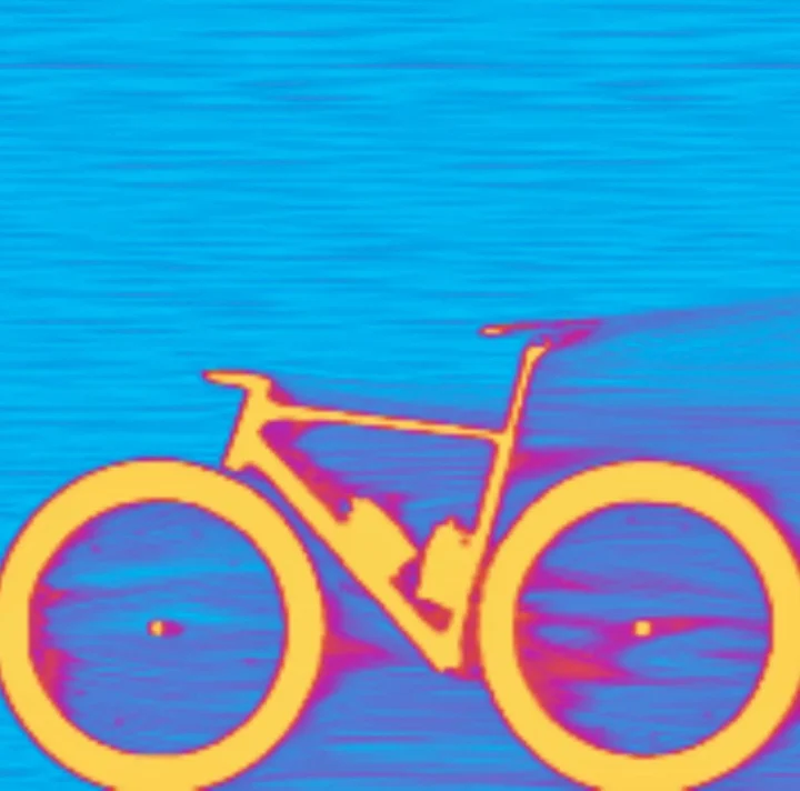 Ein Rennrad als Wärmebild: die Umrisse leuchten orange vor blauem Grund