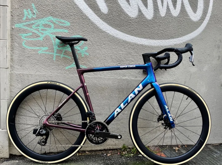 Alan Super Corsa: Carbon-Rennrad in Blue/Golden Purple, aufgebaut mit SRAM Force E1 2×12, Carbon-Laufrädern und Deda-Alanera-Cockpit