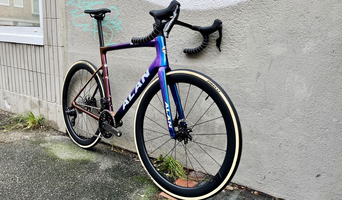 Rennrad Alan Super Corsa aus Carbon, custom made als Aufbau des Rahmen-Gabel-Sets von at Fahrräder als Spezialität des Hauses, in der eigenen Fahrradwerkstatt im Fahrradladen in Lübeck, mit elektronischer Schaltung SRAM Force E1 2x12, Carbon-Laufrädern, Carbon-Vorbau-Lenker Einheit Deda Alanera DS in Speziallackierung Blue/Golden Purple in Rahmengröße L - wir lieben das Rennrad und den Radsport!